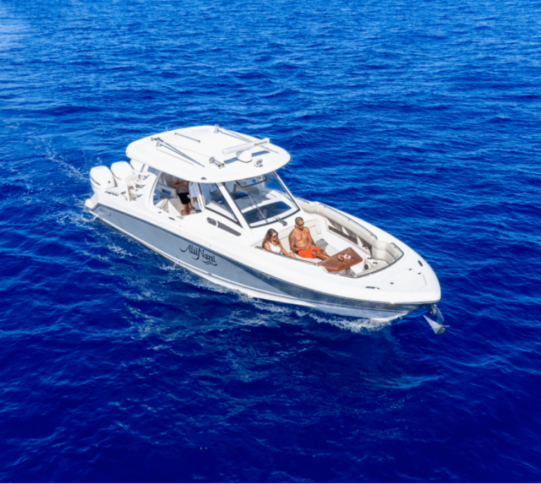 White motorboat with people on deck in blue ocean water