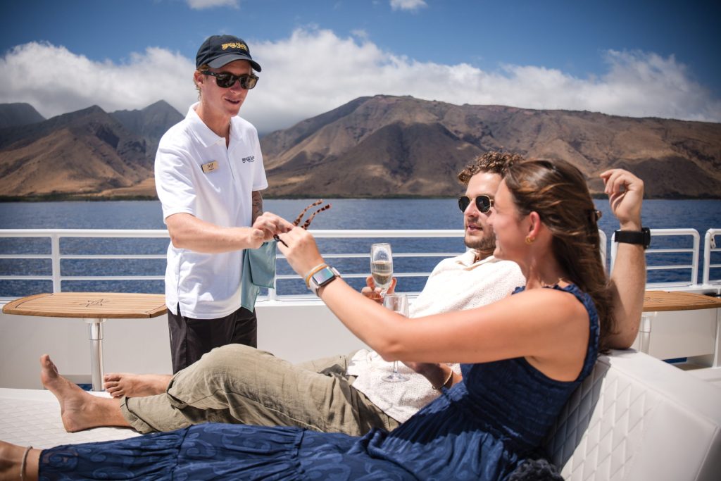 People relaxing on a boat with mountains in the background.