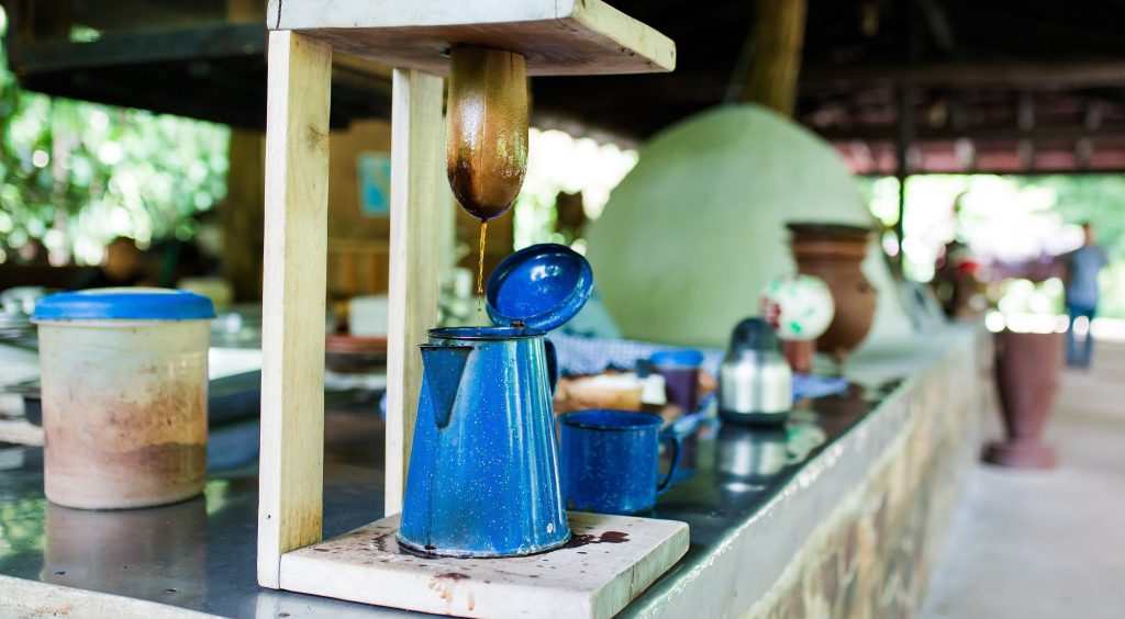 Traditional coffee brewing device with blue pot on a rustic kitchen counter.
